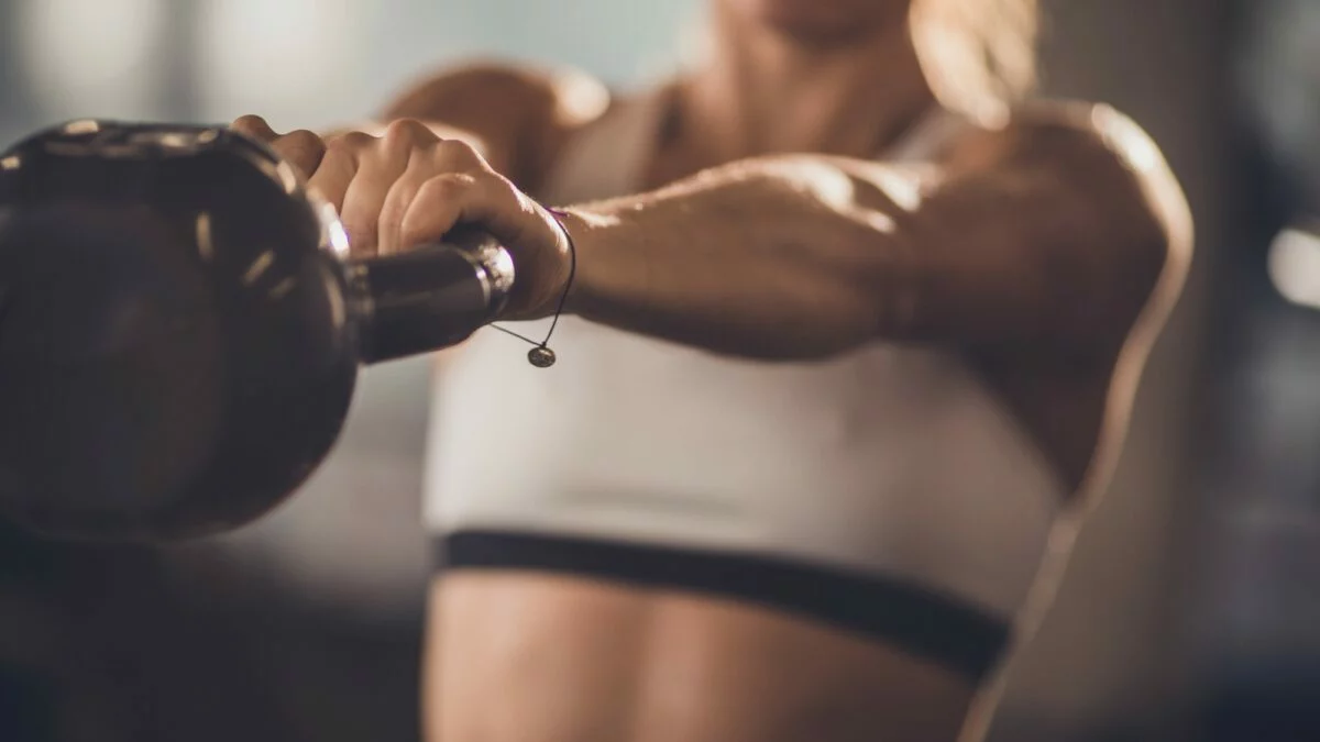 Mulher mostrando como fazer um treino de força completo na academia